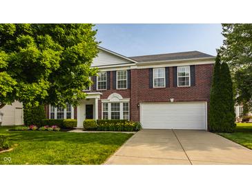 Charming two-story brick home with a well-manicured lawn and a two-car garage at 10248 Noble Ct, Indianapolis, IN 46234