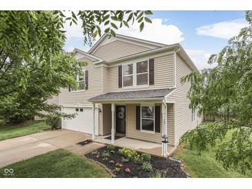 Charming two-story home features a well-maintained lawn, flower beds, and an attached two-car garage at 10510 Mcclain Dr, Brownsburg, IN 46112