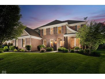 Elegant brick home with manicured lawn and lush landscaping, perfect for sophisticated living at 14662 Woodstone Cir, Fishers, IN 46037