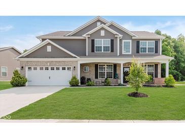 Beautiful two-story home featuring a well-maintained lawn, inviting front porch, and attached two-car garage at 1715 Foudray S Cir, Avon, IN 46123