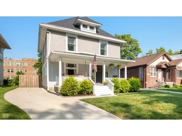 Charming two-story home with a inviting front porch, manicured lawn, and a curved driveway at 22 N Bolton Ave, Indianapolis, IN 46219