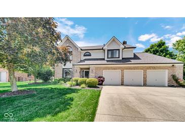 Charming two-story home featuring a three-car garage, brick accents, and well-manicured landscaping at 318 Meadowview Ln, Greenwood, IN 46142
