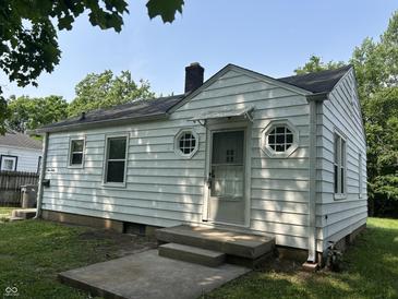 Charming single-story home featuring unique round windows, white siding, and a covered front door at 330 S Butler Ave, Indianapolis, IN 46219