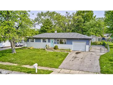 Charming single-story home features a well-maintained front yard, driveway, and beautiful trees at 3414 Ferncliff Ave, Indianapolis, IN 46227
