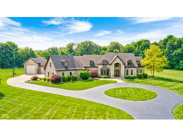 Stunning home with lush landscaping, circular driveway, and beautiful architectural details at 4181 Whitetail Woods Dr, Bargersville, IN 46106