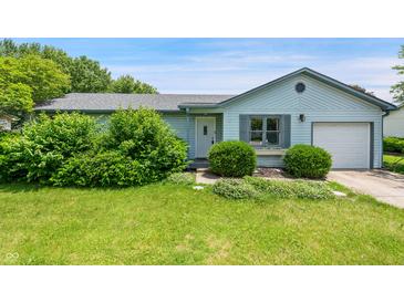 Charming single-story home with light blue siding, an attached garage, and lush front yard landscaping at 5380 Collett E Dr, Camby, IN 46113
