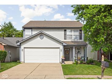 Charming two-story home with a two-car garage, tidy landscaping, and inviting front porch at 5966 Draycott Dr, Indianapolis, IN 46236