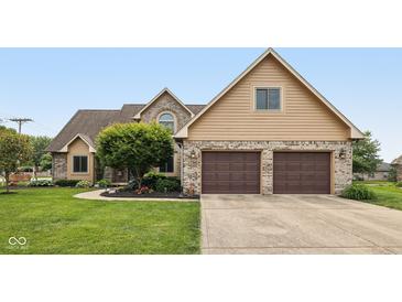Charming home featuring a two-car garage, brick accents, mature landscaping, and a well-manicured lawn at 6983 White Oak Dr, Avon, IN 46123