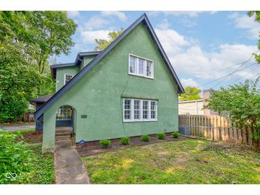 Unique green home features a distinct, charming architectural design and well-kept lawn at 715 Kessler Blvd E Dr, Indianapolis, IN 46220