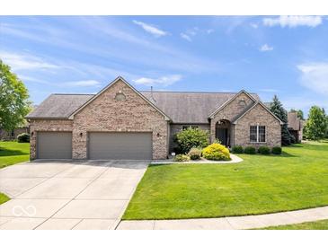 Brick ranch home with a three-car garage, well-kept lawn and manicured landscaping at 745 Ridge Gate Dr, Brownsburg, IN 46112
