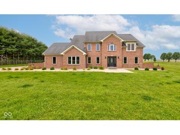 Stately brick home featuring well-manicured front lawn and beautiful architectural details under a picturesque blue sky at 8371 N 400 W, Fairland, IN 46126