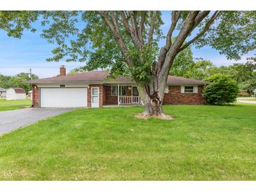 Charming brick ranch home featuring an attached garage, a manicured lawn, and mature shade trees at 9458 Dawn Dr, Brownsburg, IN 46112