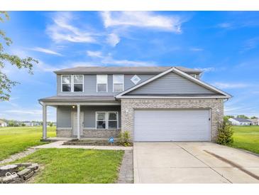 Charming two-story home featuring gray siding, a brick accent wall, and a two-car garage at 9692 Centennial Ct, Avon, IN 46123