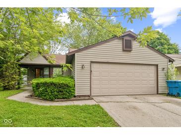 Charming home featuring a two-car garage, mature landscaping, and a well-maintained lawn at 11114 Wismar Dr, Indianapolis, IN 46235