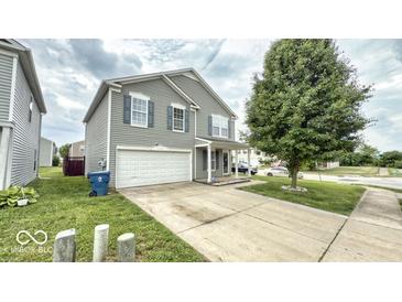 Two-story home with gray siding, white garage door, and well-maintained front lawn at 11303 Cuyahoga Dr, Indianapolis, IN 46235