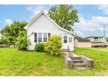 Charming white bungalow with a quaint front yard and concrete steps to the front door at 2009 S L St, Elwood, IN 46036