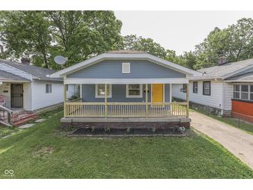 Charming home featuring a welcoming front porch with a bright yellow door and a well-maintained lawn at 2945 N Denny St, Indianapolis, IN 46218