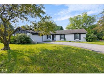 Charming single-story home featuring a white brick exterior, black shutters, an attached garage, and a well-maintained front yard at 3141 Citadel Ct, Indianapolis, IN 46268