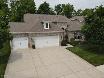 Charming single-Gathering home boasts a three-car garage, manicured lawn, and traditional brick facade at 4232 Parliament Way, Avon, IN 46123