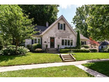 Charming brick home with professionally landscaped front yard and mature trees at 5681 Carrollton Ave, Indianapolis, IN 46220