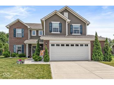 Charming two-story home with a brick and vinyl exterior, well-manicured lawn, and an attached two-car garage at 7603 Merrick Dr, Brownsburg, IN 46112