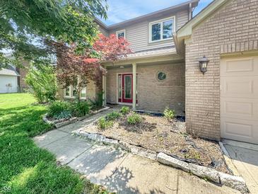 Charming two-story home with brick and vinyl siding, a well-manicured lawn, and a colorful red Japanese maple tree at 812 Timber Creek Dr, Indianapolis, IN 46239