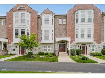 Charming townhouse exterior featuring a brick facade, bay windows, landscaped front yard, and welcoming entryway at 11872 Salerno Ct, Carmel, IN 46032