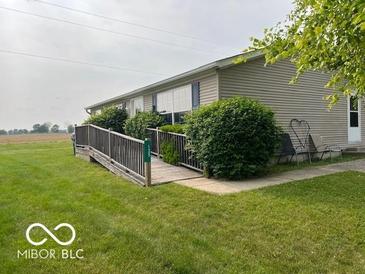 Ranch home featuring a wheelchair ramp, neat landscaping, and two patio chairs at 135 Sunset Ct, Cicero, IN 46034