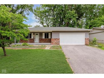 Charming single-story home featuring a brick facade, attached garage, and well-maintained lawn at 1410 Lawrence Ave, Indianapolis, IN 46227