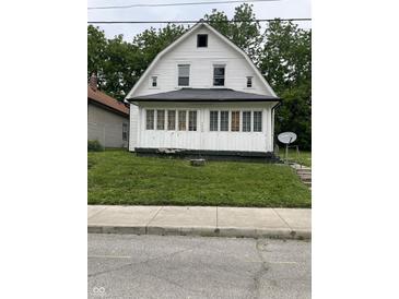 A white house with a front porch and green lawn shows the property's curb appeal at 1630 E 18Th St, Indianapolis, IN 46218