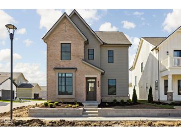 Charming two-story home boasts a mix of brick and siding and professional landscaping at 1655 Fernley Dr, Westfield, IN 46074