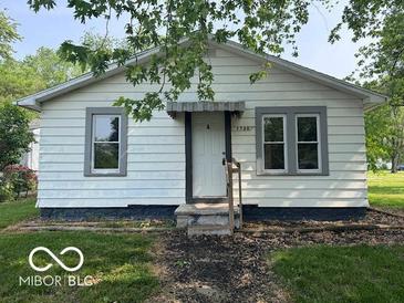 Quaint one-story home featuring neutral siding, trimmed windows, front entrance, and a well-manicured lawn at 1720 E Cornell Ave, Muncie, IN 47303