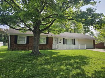 Charming brick ranch-style home featuring a well-manicured lawn and mature shade tree in front yard at 2017 Schwier Ct, Indianapolis, IN 46229