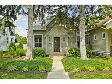 Charming home with mature trees and landscaped front yard and a pathway leading to the front door at 2158 S Garfield Dr, Indianapolis, IN 46203