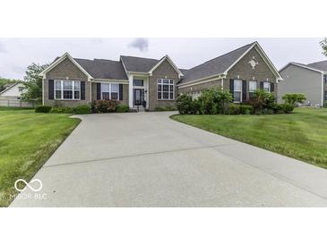Charming brick home featuring a well-manicured lawn and an expansive driveway at 2502 Colinbrook Pkwy, Greenwood, IN 46143