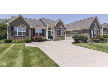 Charming brick home featuring an attached garage, lush landscaping, and an inviting curb appeal at 2502 Colinbrook Pkwy, Greenwood, IN 46143