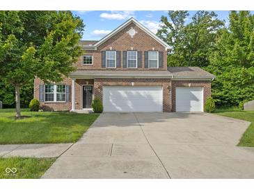 Charming two-story brick home with a three-car garage and manicured lawn at 3068 Reflection Ct, Greenwood, IN 46143