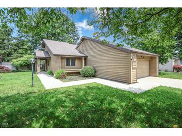 Charming single-story home features a one-car garage, manicured lawn, and mature trees at 4462 Carya Sq, Columbus, IN 47201