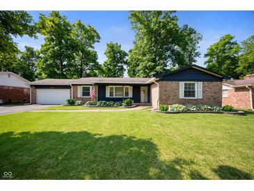 Charming single-Gathering home with brick and blue siding plus a manicured lawn and landscaping at 5625 Winston Dr, Indianapolis, IN 46226