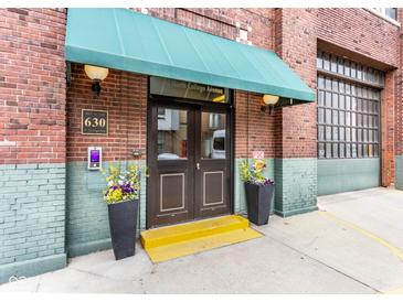 Building entrance with a brown double door, flowers and a green awning with the address above at 630 N College Ave # 409, Indianapolis, IN 46204