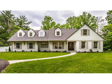 Charming home with white brick and siding, dormer windows, and a walkway leading to the front door at 7105 Sylvan Ridge Rd, Indianapolis, IN 46240