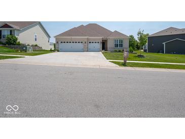 A charming single-story home features a brick facade, a well-manicured lawn, and an attached two-car garage at 7329 Birch Leaf Dr, Indianapolis, IN 46259