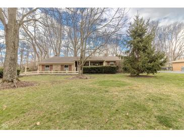 Charming single-story brick home with well-maintained lawn and mature trees in a peaceful neighborhood setting at 10130 Central Ave, Carmel, IN 46280