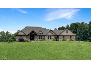 Charming brick home featuring a large front lawn, complemented by a well-manicured landscape and natural accents at 1412 10Th St, Danville, IN 46122