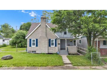 Charming two-story home featuring a stone chimney, blue shutters, and a well-maintained lawn at 1618 Villa Ave, Indianapolis, IN 46203