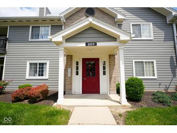 Inviting entrance to unit 207 with a red door and well-maintained landscaping at 207 Keats Ct # 102, Carmel, IN 46032