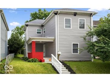 Charming two-story home featuring a red-brick porch, gray siding, and a well-maintained lawn at 4923 E University Ave, Indianapolis, IN 46201