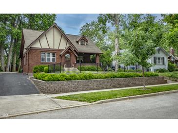 Charming Tudor-style home with brick facade, manicured landscaping, and inviting curb appeal at 5024 N Kenwood Ave, Indianapolis, IN 46208