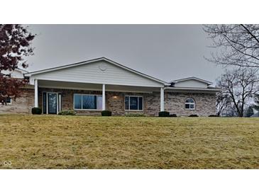 Charming brick home featuring a covered porch with white columns and manicured landscaping at 5939 Brendonridge S Ct, Indianapolis, IN 46226