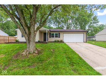 Charming single-story home featuring an attached garage, mature trees, and a well-maintained lawn at 6310 Kellum Dr, Indianapolis, IN 46221